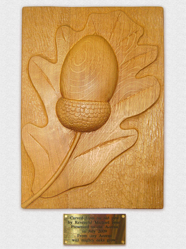 Woodcarving of an acorn on an oakleaf